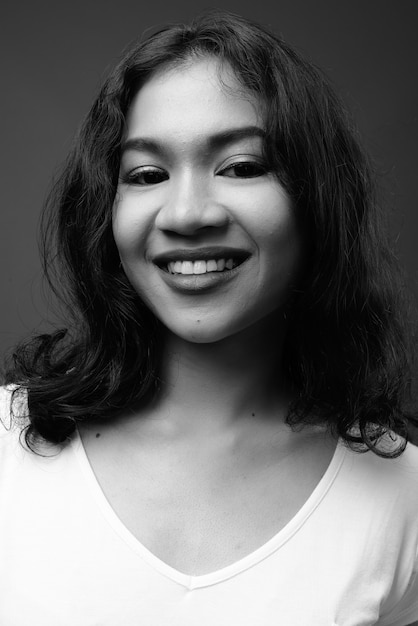 giovane bella donna asiatica contro il muro grigio in bianco e nero