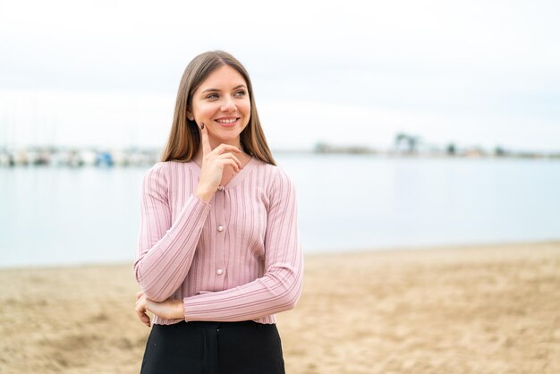 Giovane bella donna bionda che pensa un'idea mentre cerca