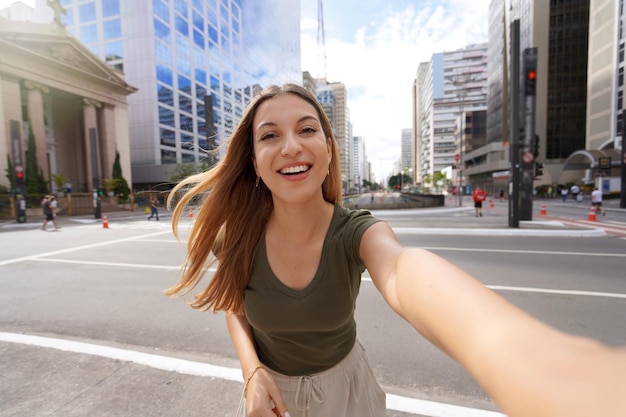 Giovane bella donna brasiliana con abiti eleganti prende autoritratto sull'Avenida Paulista Sao Paulo Brasile