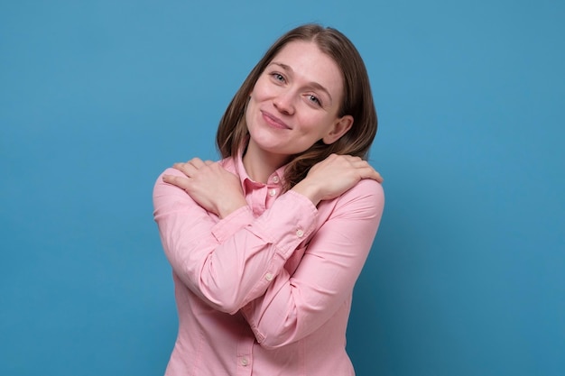 Giovane bella donna castana che si abbraccia felice e positivo sorridente sicuro