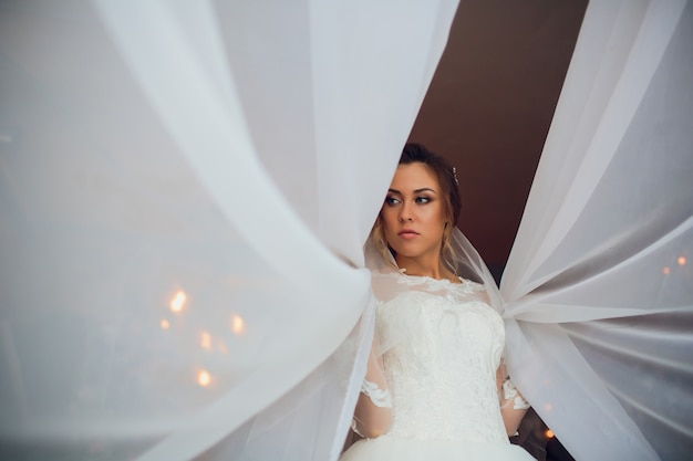 Giovane bella donna castana in vestito da sposa.