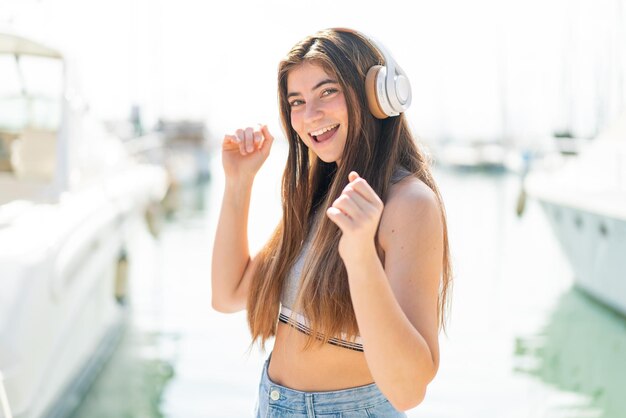 Giovane bella donna caucasica che ascolta musica e balla