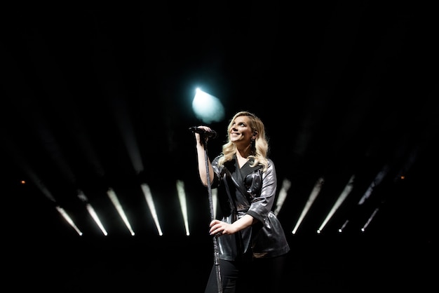 Giovane bella donna che canta in fumo bianco, da vicino.