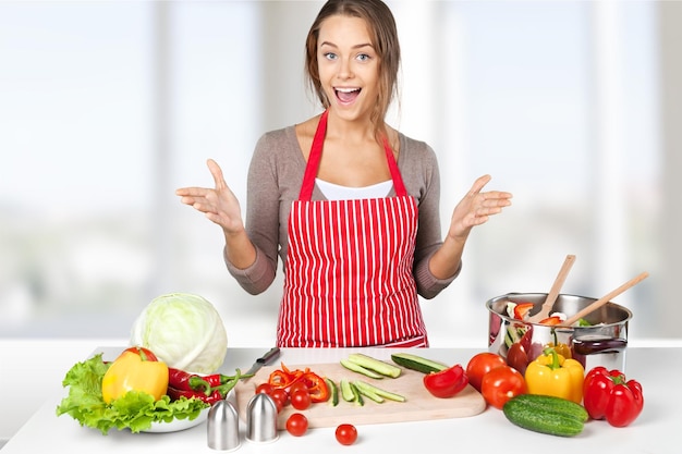 Giovane bella donna che cucina in cucina