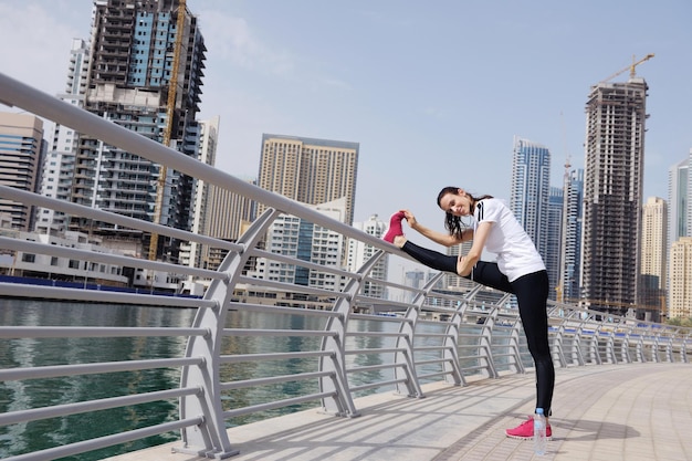 Giovane bella donna che fa jogging e corre la mattina al parco della città. Donna nello sport all'aperto concetto di salute e fitness