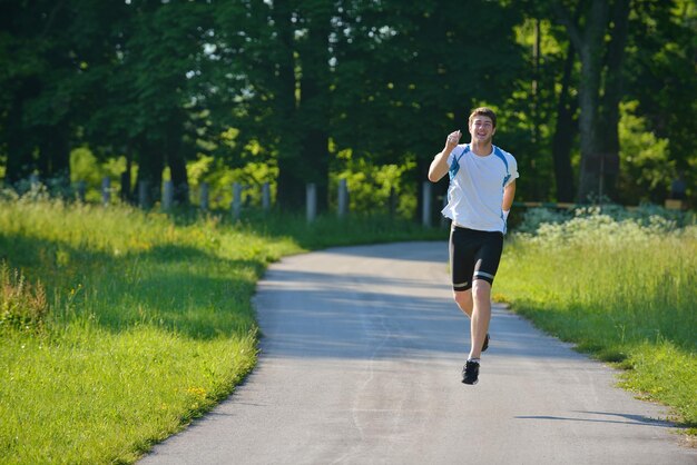 Giovane bella donna che fa jogging nel parco estivo. Donna nel concetto di salute di sport all'aperto