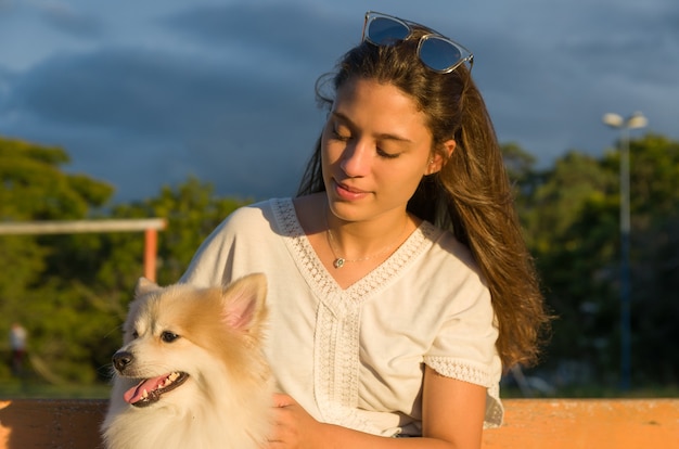 Giovane bella donna che gioca con il cane.