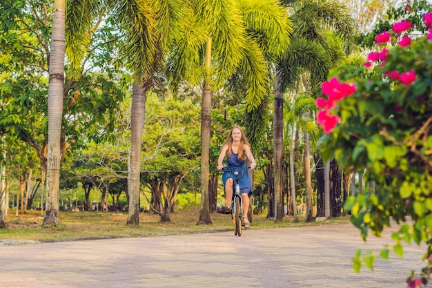 Giovane bella donna che guida una bicicletta in una gente attiva del parco all'aperto