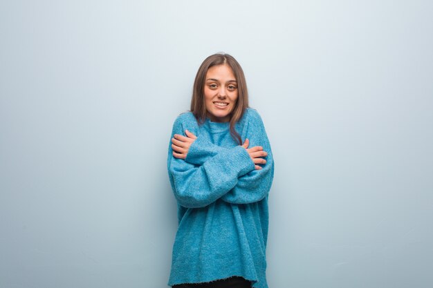 Giovane bella donna che indossa un maglione blu andando a freddo a causa della bassa temperatura