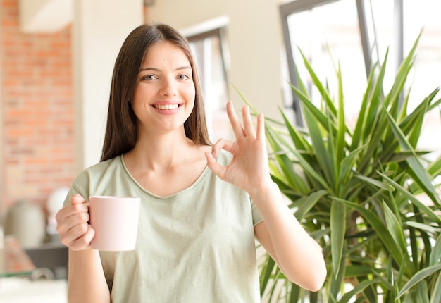 Giovane bella donna che prende un caffè a casa