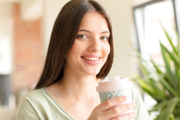 Giovane bella donna che prende un caffè a casa