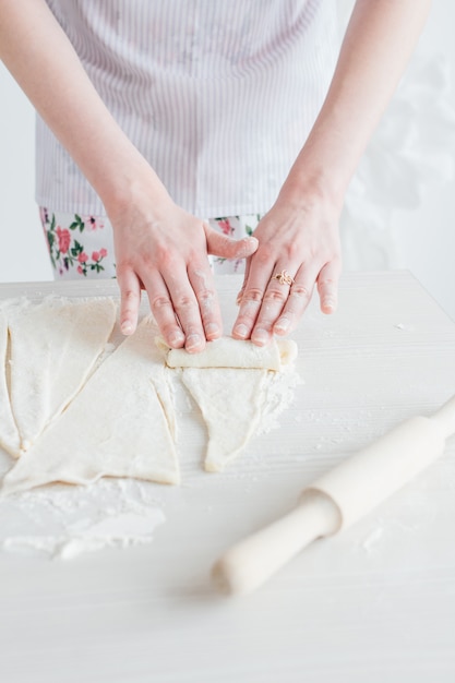 Giovane bella donna che prepara i cornetti fatti in casa