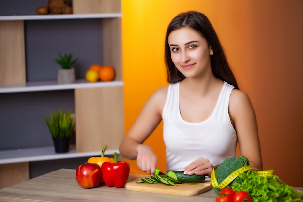 Giovane bella donna che prepara insalata sana di dieta