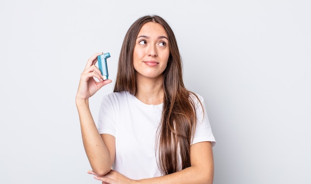 Giovane bella donna che scrolla le spalle, sentendosi confusa e incerta. concetto di asma