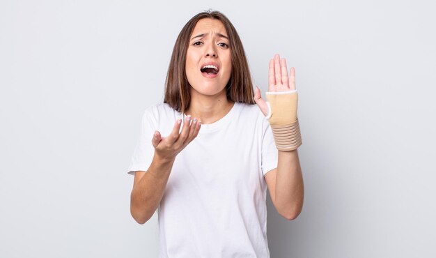 Giovane bella donna che sembra disperata, frustrata e stressata, concetto di fasciatura della mano