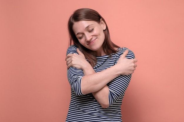 Giovane bella donna che si abbraccia felice e positiva sorridente sicura