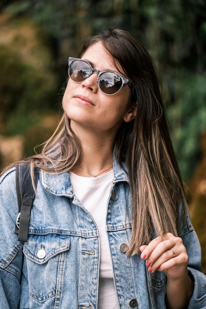 Giovane bella donna che si rilassa toccando i suoi capelli lisci