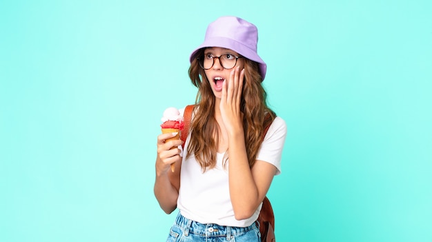 giovane bella donna che si sente felice, eccitata e sorpresa con in mano un gelato. concetto di estate