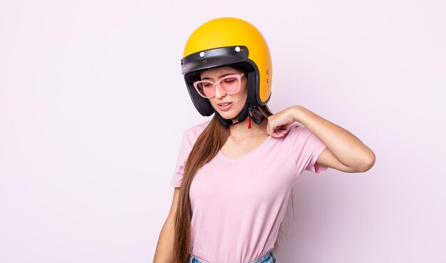 Giovane bella donna che si sente stressata, ansiosa, stanca e frustrata. motociclista e casco