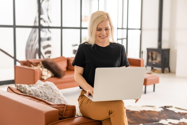 giovane bella donna che utilizza un computer portatile a casa.