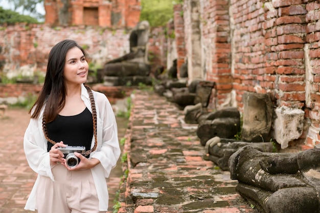 Giovane bella donna che viaggia e che scatta foto al parco storico tailandese