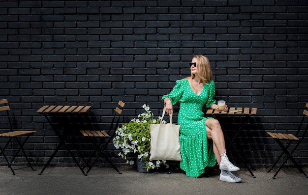 Giovane bella donna con borsa ecologica in lino sullo sfondo della città?