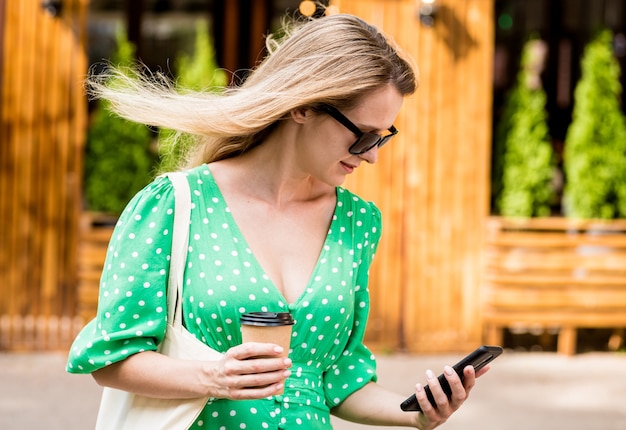 Giovane bella donna con borsa ecologica in lino sullo sfondo della città?