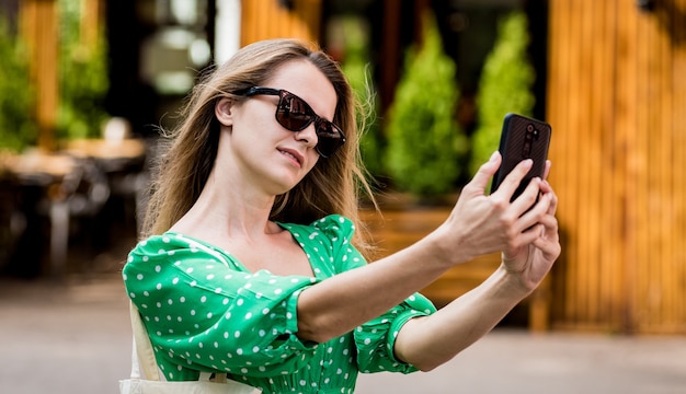 Giovane bella donna con borsa ecologica in lino sullo sfondo della città?