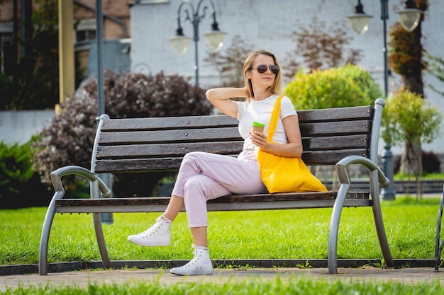 Giovane bella donna con borsa ecologica in lino sullo sfondo della città