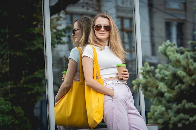 Giovane bella donna con borsa ecologica in lino sullo sfondo della città