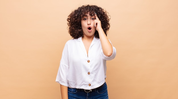 giovane bella donna con i capelli ricci e una camicia bianca