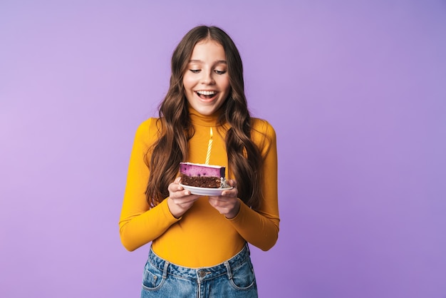 giovane bella donna con lunghi capelli castani che sorride e tiene in mano una torta di compleanno isolata