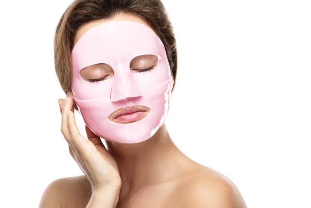 Giovane bella donna con maschera facciale in gomma sul viso