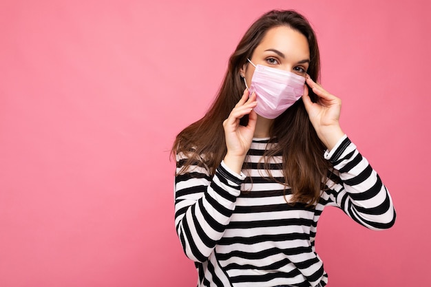 Giovane bella donna con maschera protettiva anti-virus riutilizzabile sul viso