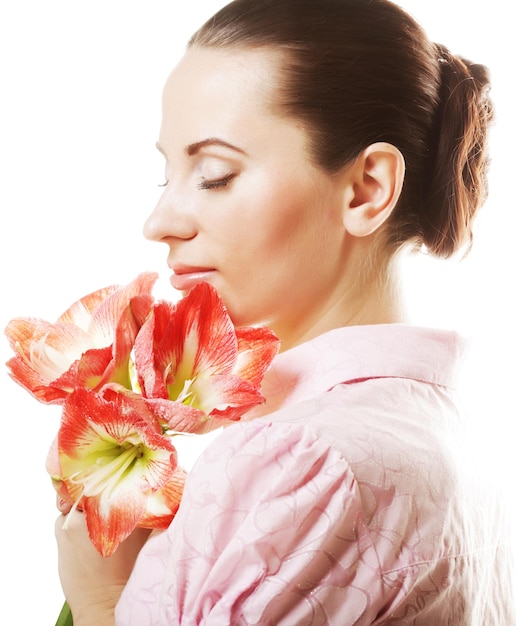 Giovane bella donna con trucco fresco e splendido fiore rosa su sfondo bianco