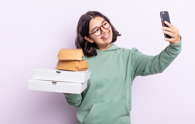 Giovane bella donna con uno smartphone e porta via il concetto di fast food