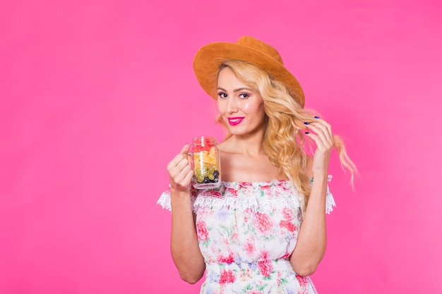 Giovane bella donna con vaso di frutta