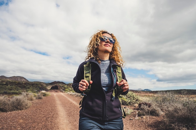 Giovane bella donna con zaino e vestiti da trekking escursioni in montagna. Concetto di stile di vita sano e attivo.