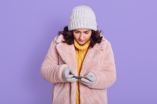 Giovane bella donna concentrata in posa isolata sopra la parete lilla