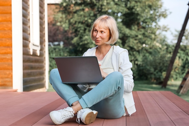 Giovane bella donna d'affari che lavora su un laptop freelancer lavora in natura Imprenditrice al lavoro all'aperto