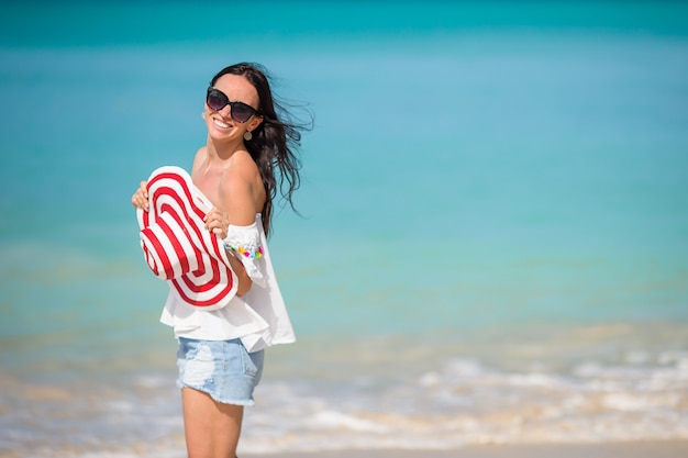 Giovane bella donna divertendosi sulla spiaggia tropicale.