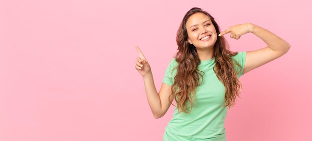 Giovane bella donna e indicando lo spazio della copia