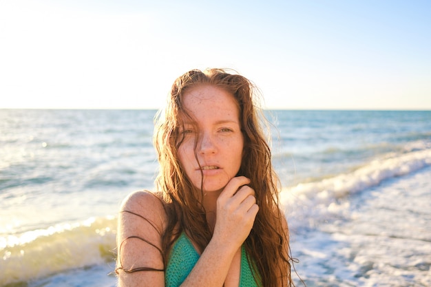 Giovane bella donna esile sulla spiaggia di tramonto