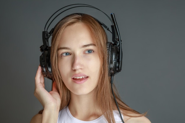 Giovane bella donna in abito luminoso che si gode la musica a casa