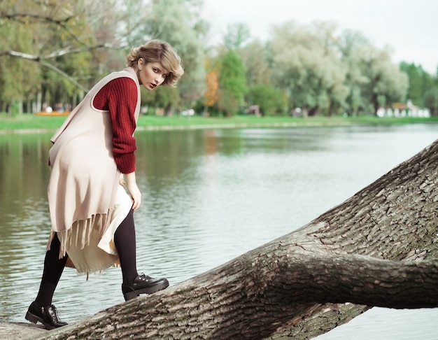 Giovane bella donna in posa su un albero. Ritratto di moda glamour.