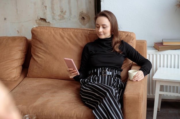 Giovane bella donna in un accogliente caffè moderno