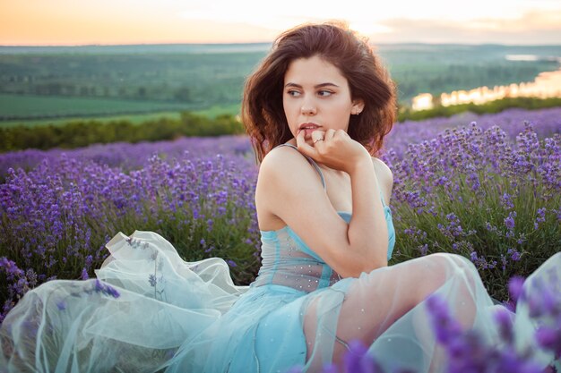 Giovane bella donna in un campo di lavanda