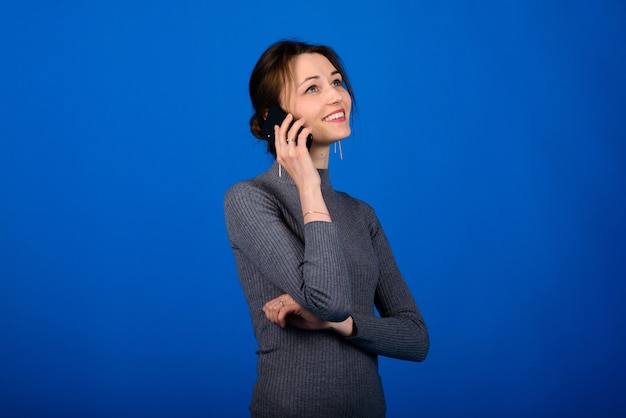 Giovane bella donna in un maglione grigio