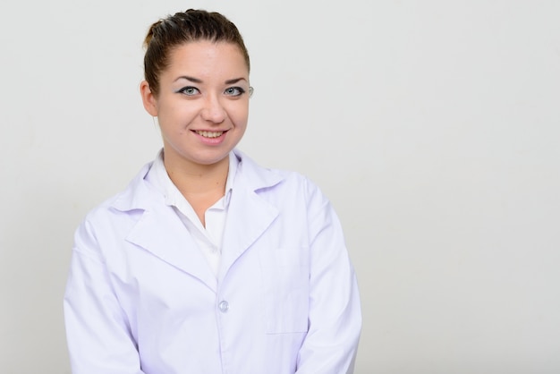 giovane bella donna medico con i capelli castani contro lo spazio bianco