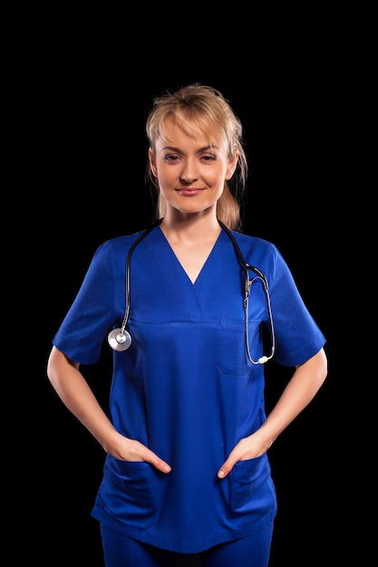 Giovane bella donna medico in camice con stetoscopio isolato su sfondo nero